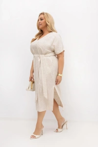 Boczne ujęcie beżowej sukienki plus size z paskiem w talii i efektownym rozporkiem. Lekko opływający fason oraz eleganckie wykończenie sprawiają, że model pięknie prezentuje się na sylwetce.