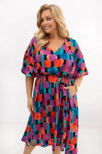 Zbliżenie na sukienkę plus size Arie w kolorowe koła ukazuje dekolt V, pasek wiązany w talii oraz efektowny print w odcieniach turkusu, fioletu i pomarańczu na lekkiej wiskozie.