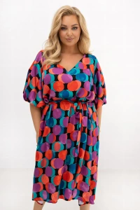 Sukienka plus size Arie w kolorowe koła prezentowana w lekkim ujęciu z boku. Pasek podkreśla talię, a luźny fason i przewiewna wiskoza zapewniają komfort noszenia każdego dnia.