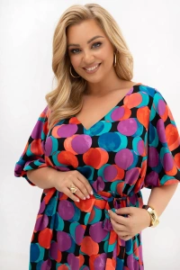 Detal sukienki plus size Arie pokazuje dekolt V, wiązany pasek oraz intensywny wzór w kolorowe koła. Zbliżenie pozwala dostrzec lekkość materiału i staranne wykończenie modelu.