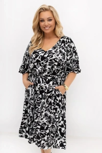 Zbliżenie na sukienkę plus size Arie z efektownym czarno-białym printem. Widoczny dekolt V, pasek w talii oraz kieszenie podkreślają kobiecy fason i wygodny krój modelu.