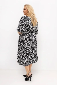 Tył sukienki plus size Arie w czarno-białym roślinnym wzorze. Luźny fason i lekka tkanina zapewniają swobodę ruchów, a pasek subtelnie podkreśla talię również z tyłu.