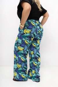 Tył spodni damskich plus size Marisa w turkusowym kolorze z egzotycznym wzorem. Widoczny prosty fason, szerokie nogawki oraz wygodny krój zapewniający swobodę ruchów.