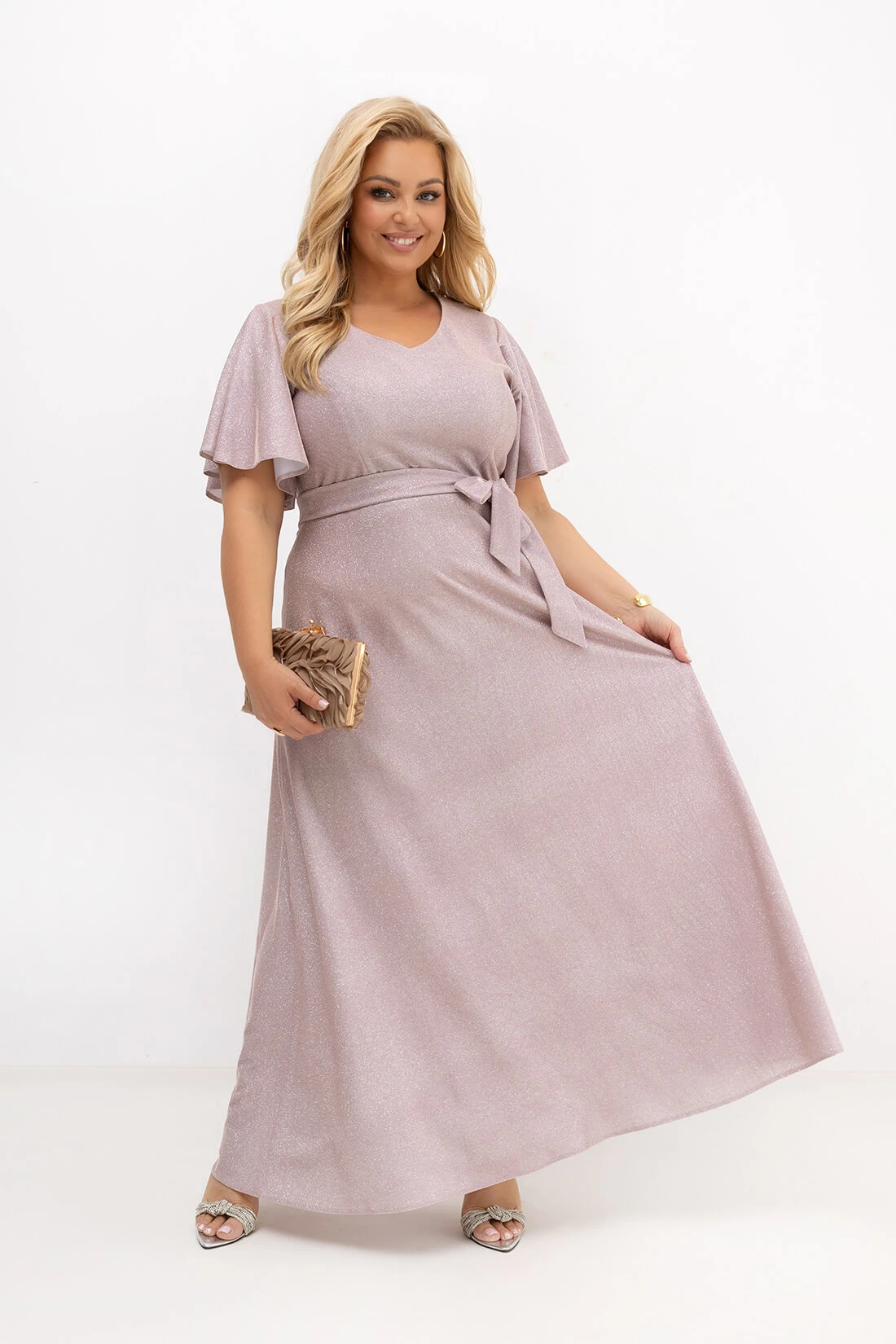 Długa sukienka maxi Wedding Glow w kolorze pudrowego różu z subtelną srebrną poświatą. Elegancka sukienka plus size z odcięciem w talii, paskiem i szerokimi rękawami. Idealna na wesele, komunię, bal oraz eleganckie przyjęcia.