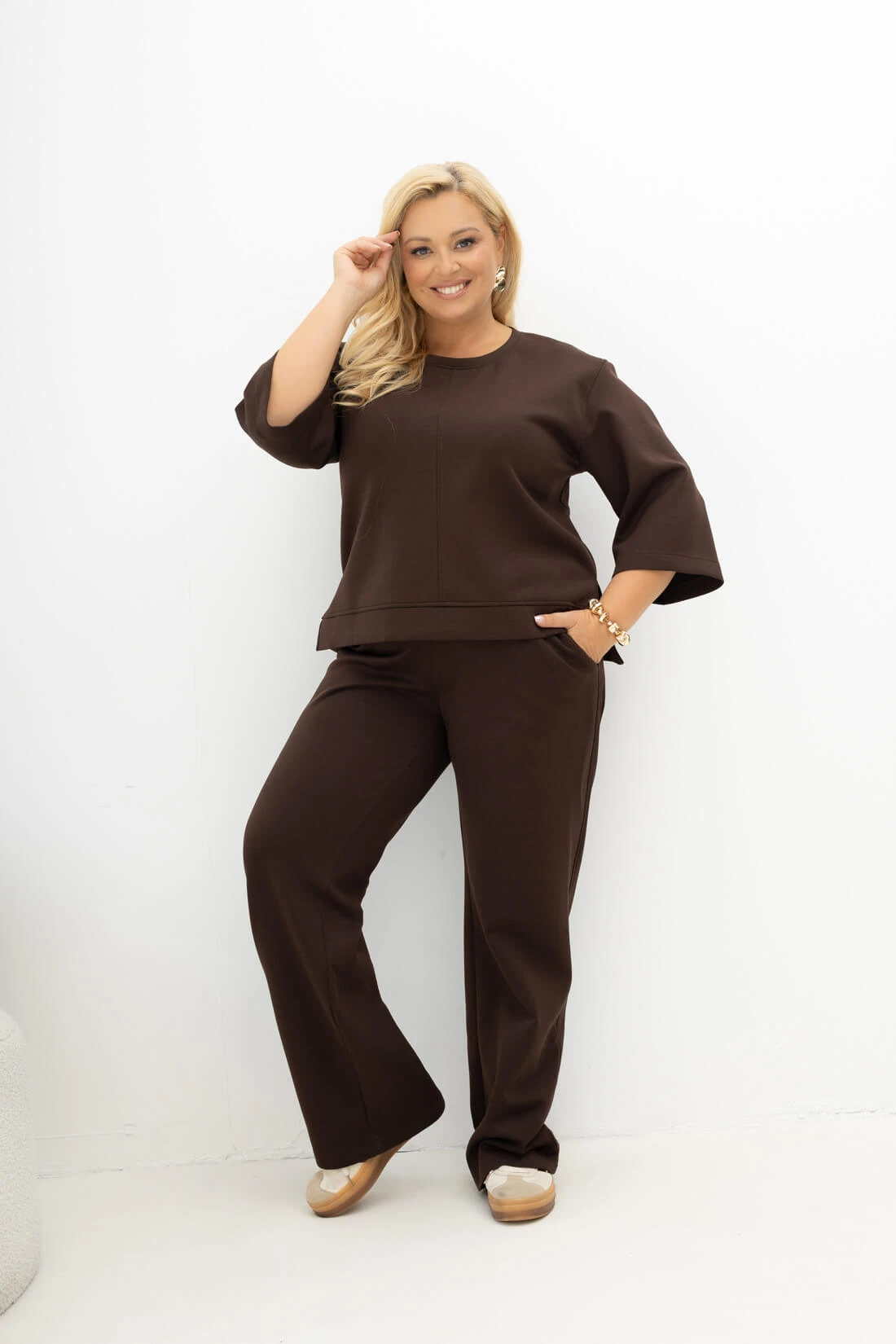Czekoladowy komplet Simple Routine Plus Size Oversize z bluzką z rękawem 3/4 oraz spodniami o prostej nogawce na gumce – stylizacja z przodu.